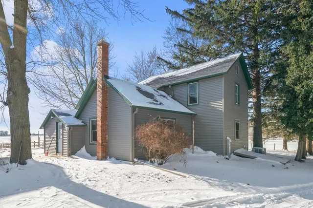 a view of a house with a yard covered in snow
