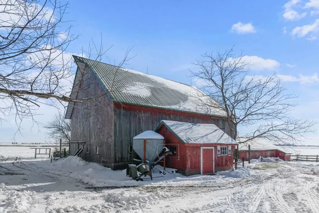 a view of a barn with a table and chairs under an umbrella