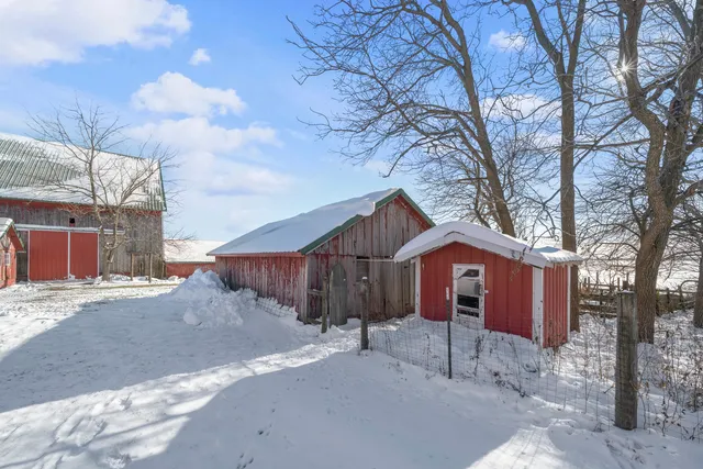 a view of a house with a yard covered in snow