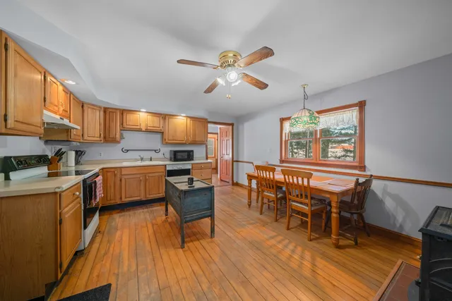a kitchen with a table chairs stove and cabinets