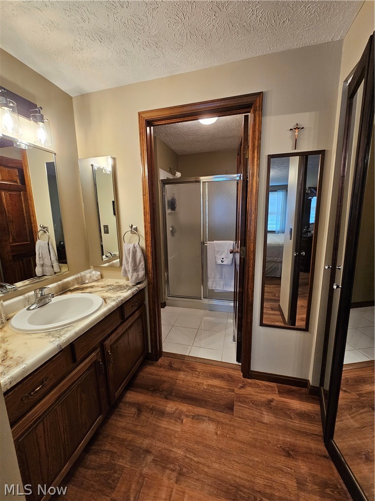 5100 Pierce Road Northwest Warren, OH 44481 - Photo 22 of 26 Bathroom featuring a textured ceiling, dark vinyl flooring, shower, and large vanity