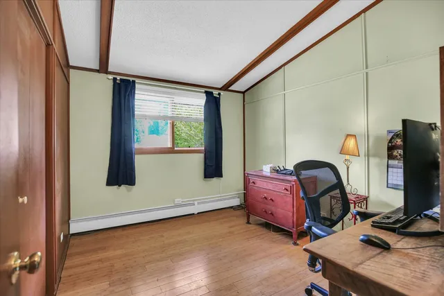 a bedroom with bed and a flat tv screen on the dresser