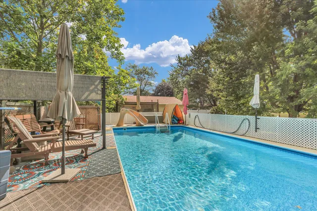 a view of house with swimming pool and sitting area