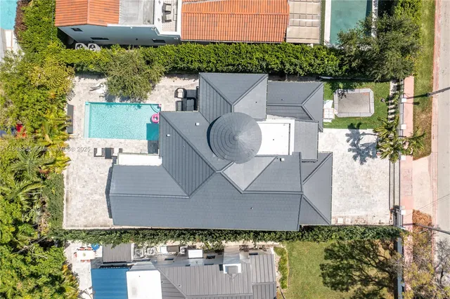aerial view of a house with yard and trees in the background