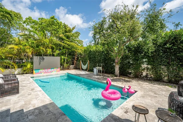 a view of a backyard with a table and chairs potted plants
