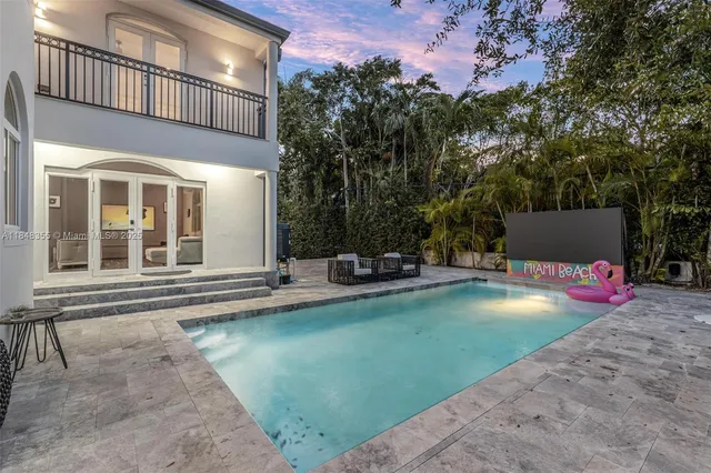 a view of a house with swimming pool and sitting area