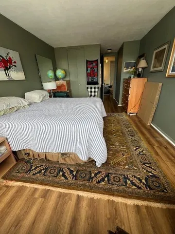 a bedroom with a bed and wooden floor