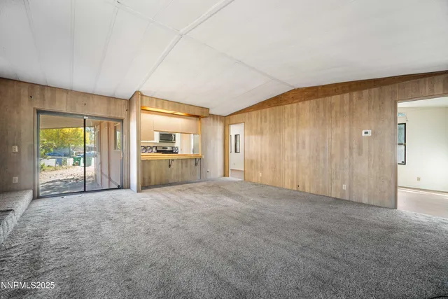an empty room with furniture and a kitchen