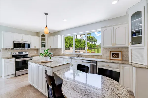 a kitchen with stainless steel appliances kitchen island granite countertop a stove a sink and a microwave