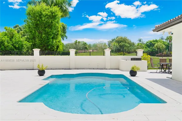 a view of a white house with a big yard and large tree