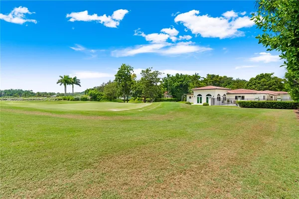 a front view of a house with a garden and trees