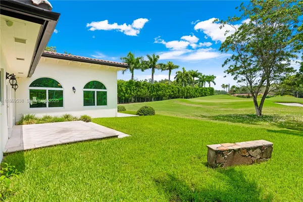a view of a fence in front of a house with a street
