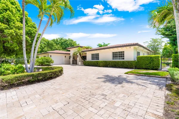 a view of a house with a yard and potted plants