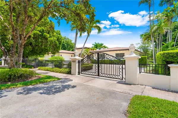 a front view of a house with a yard and potted plants