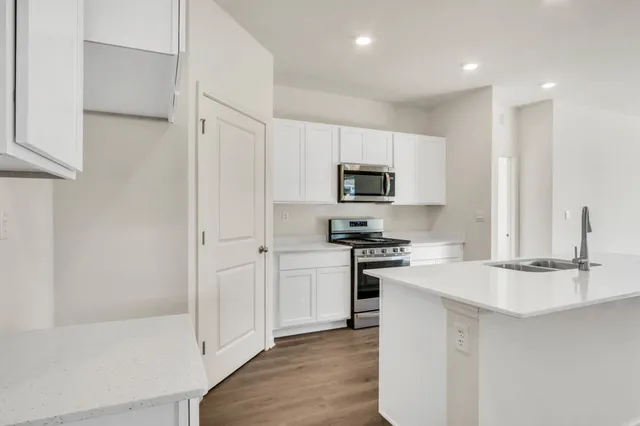 a kitchen with white cabinets and stainless steel appliances