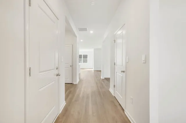 a view of a hallway with wooden floor