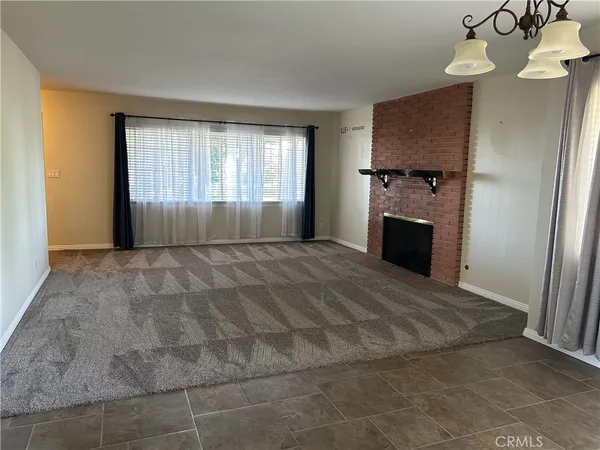 a view of empty room with a fireplace and window