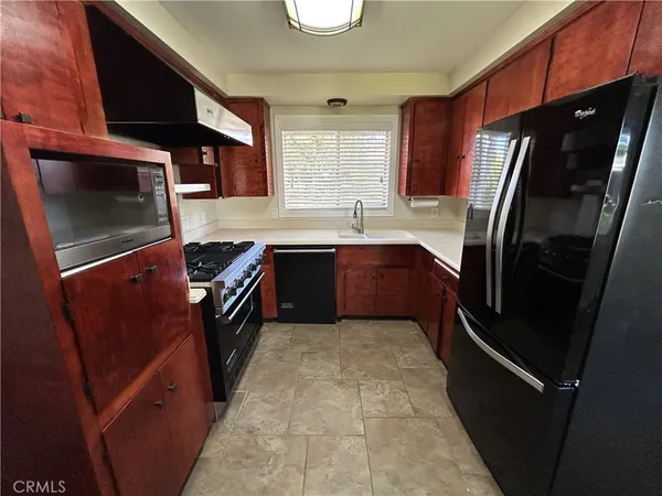 a kitchen with stainless steel appliances granite countertop a refrigerator a sink a stove and island