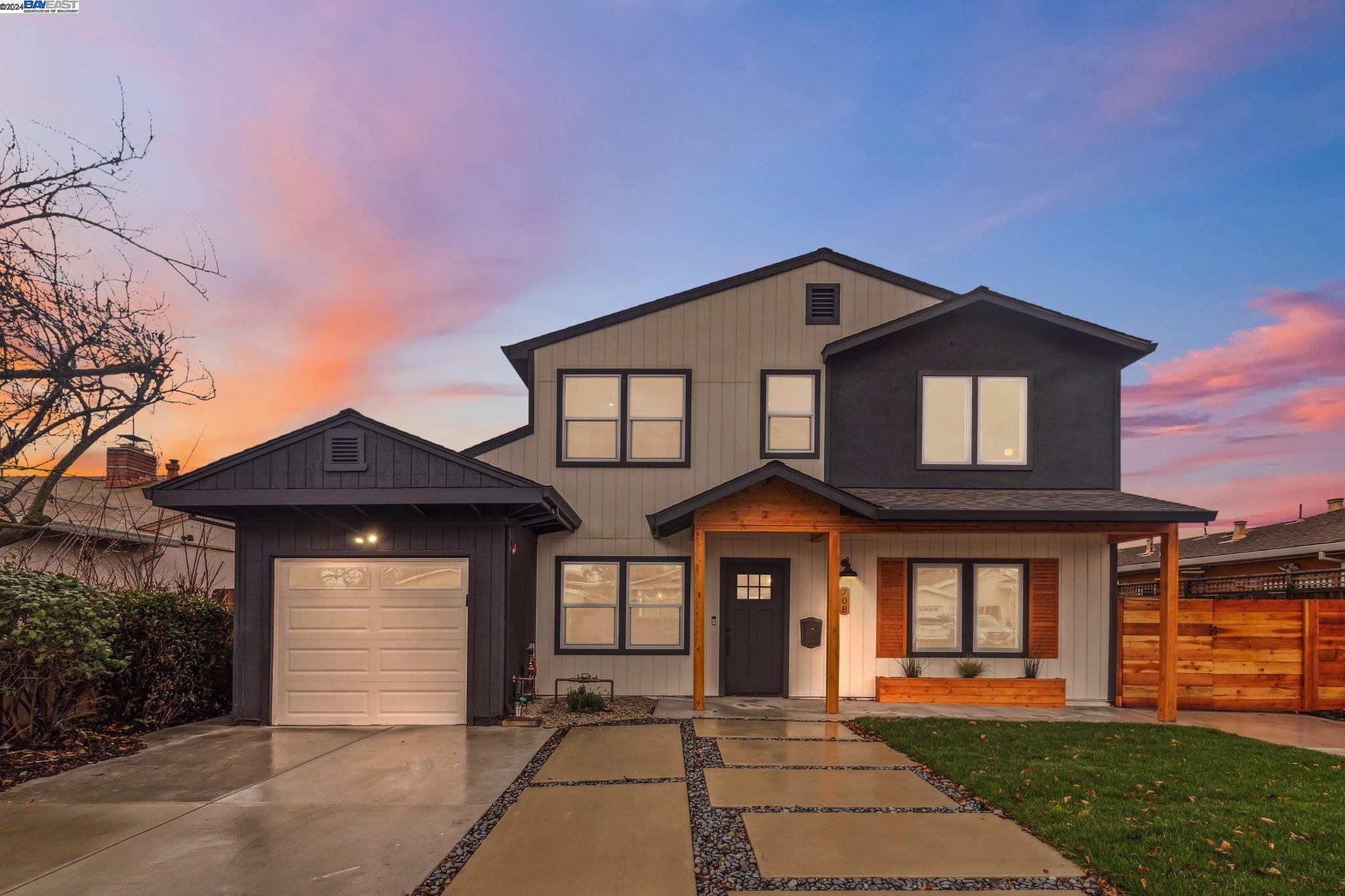 a front view of a house with a yard and potted plants