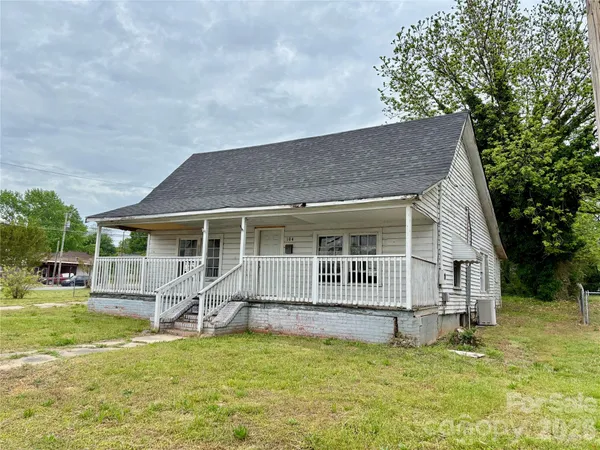 a view of a house with a yard patio and a tree