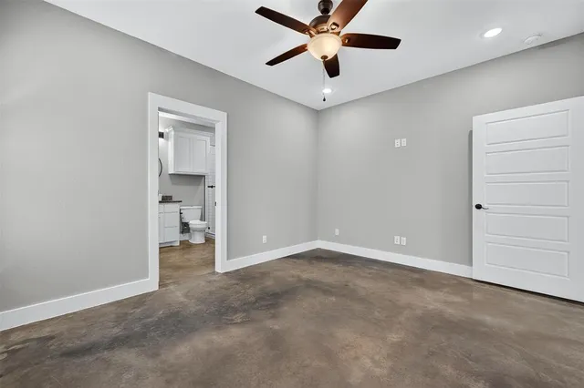 an empty room with closet and a ceiling fan