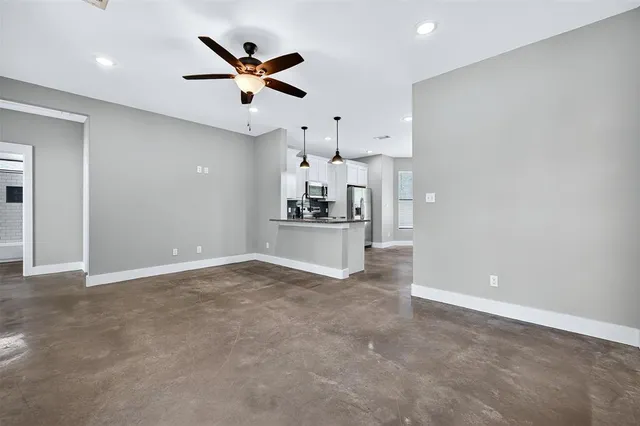an empty room with cabinet and ceiling fan