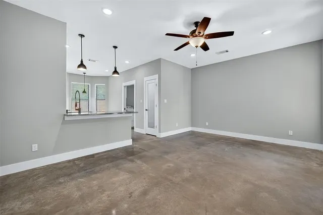 an empty room with ceiling fan and window