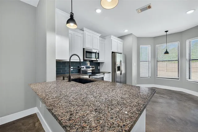 a kitchen with sink refrigerator and microwave