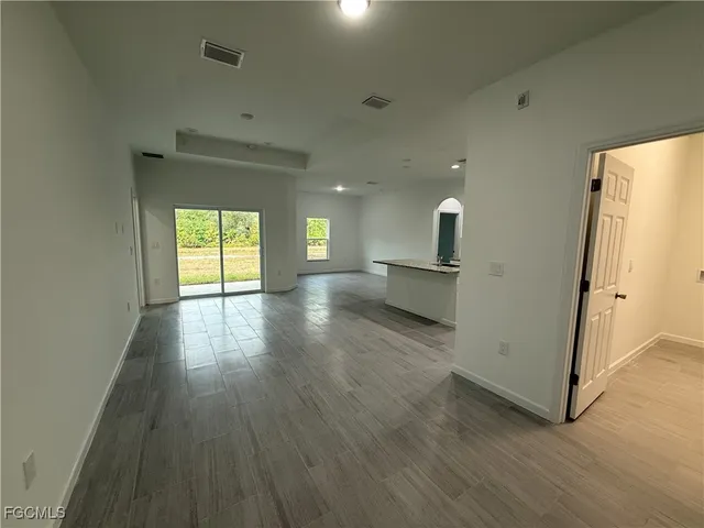 an empty room with wooden floor and a window