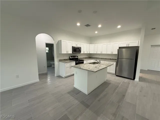a kitchen with a refrigerator and a stove top oven