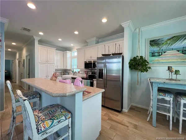 a kitchen with refrigerator and chairs