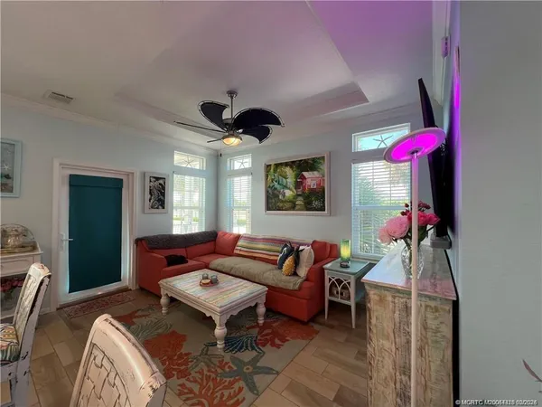 a living room with furniture a flat screen tv and a large window