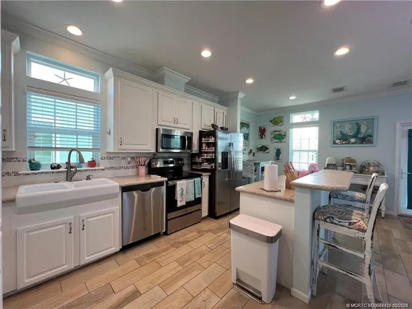 a kitchen with counter top space a sink appliances and cabinets