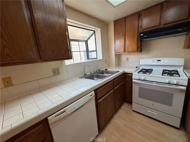a kitchen with granite countertop a stove sink and cabinets