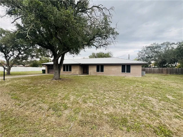 a big yard with table and chairs under an trees