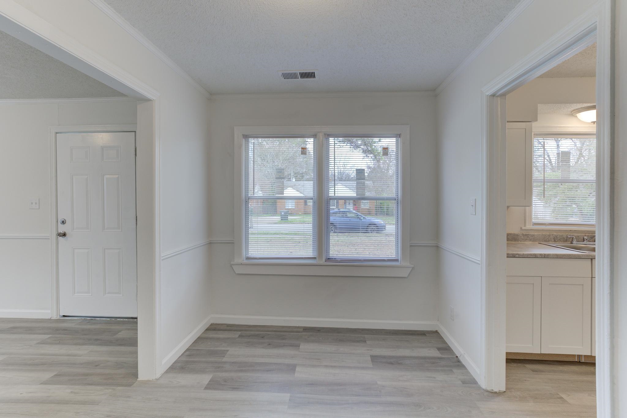 4422 Boyce Road Memphis, TN 38117 - Photo 7 of 21 a view of an empty room with wooden floor and a window