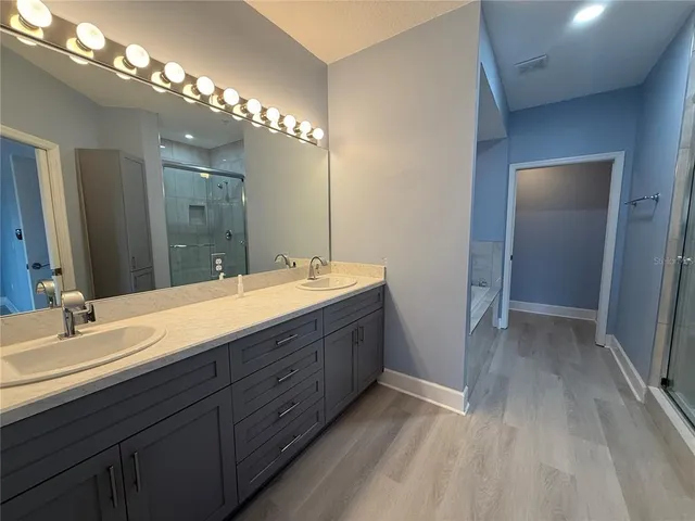 a bathroom with double vanity sink a vanity and a mirror