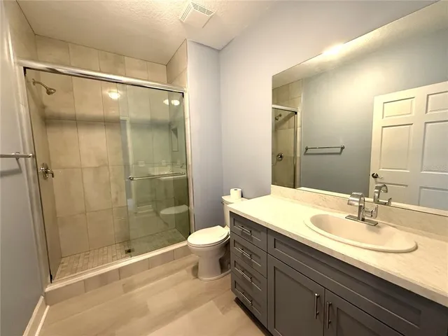 a bathroom with a granite countertop sink toilet and shower