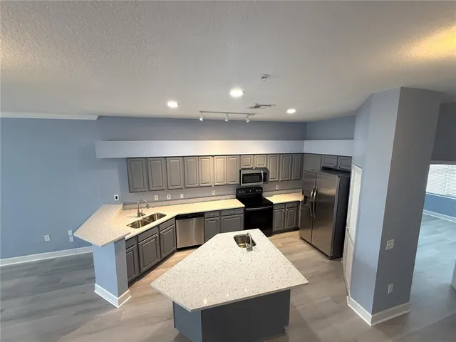 a kitchen with stainless steel appliances granite countertop a stove and a sink