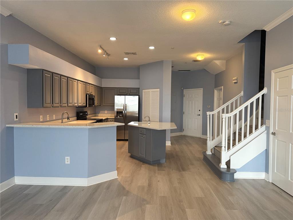116 131st Avenue East, Unit C Madeira Beach, FL 33708 - Photo 5 of 41 a living room with stainless steel appliances kitchen island granite countertop a couch and a view of kitchen