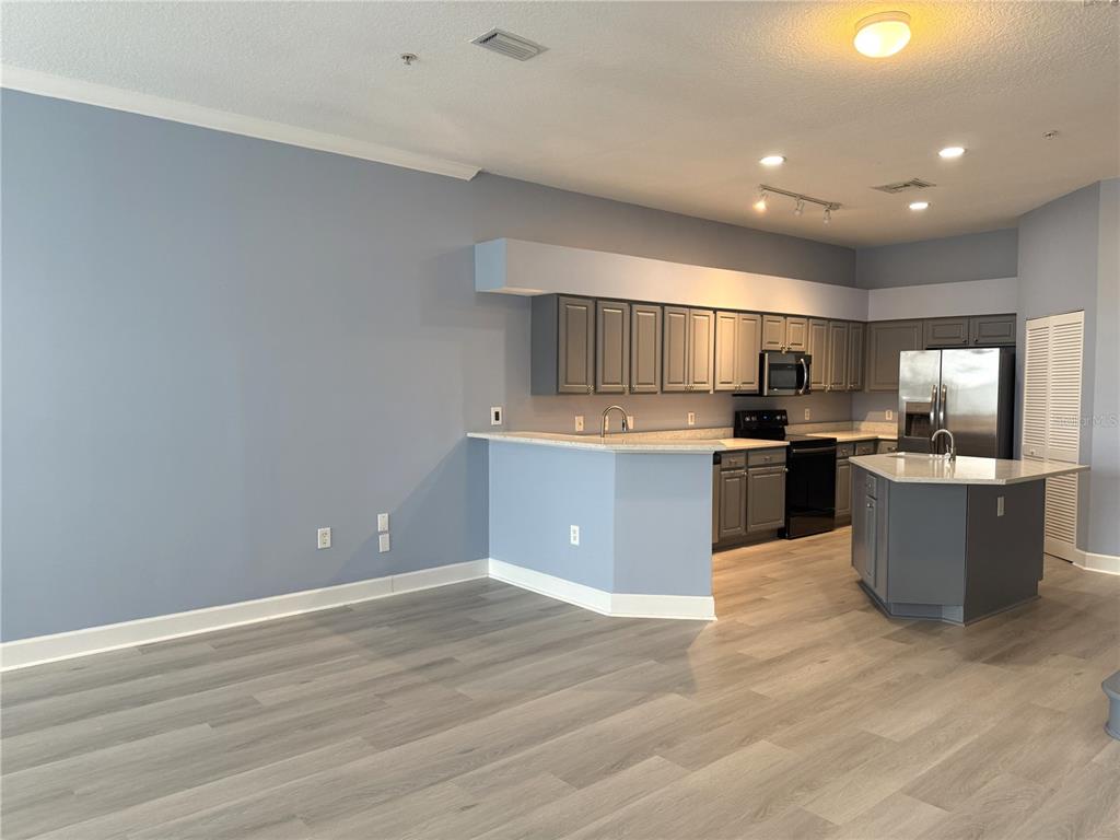 116 131st Avenue East, Unit C Madeira Beach, FL 33708 - Photo 10 of 41 a kitchen with stainless steel appliances a refrigerator and a wooden floors