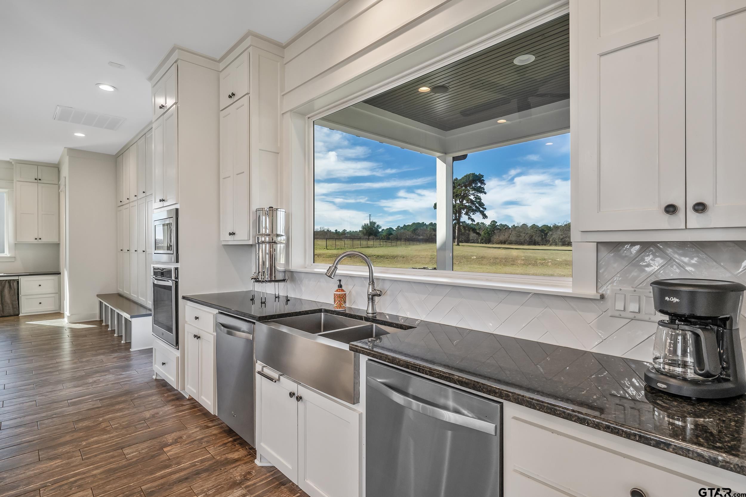 223 Riata Road Bullard, TX 75757 - Photo 12 of 45 a kitchen with stainless steel appliances a sink stove and cabinets
