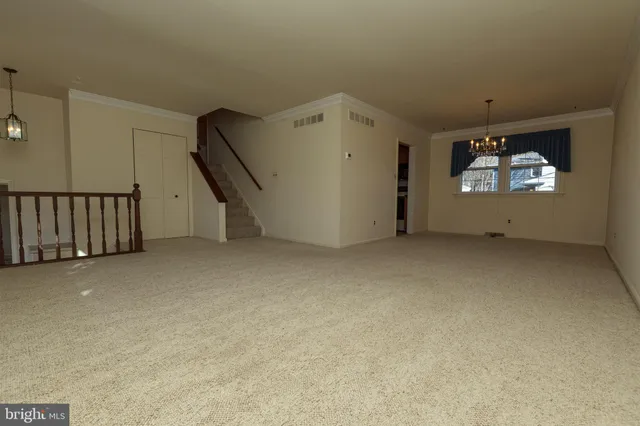 a view of an empty room with wooden floor and windows