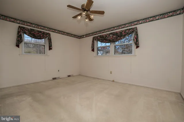 a view of a livingroom with a ceiling fan and window