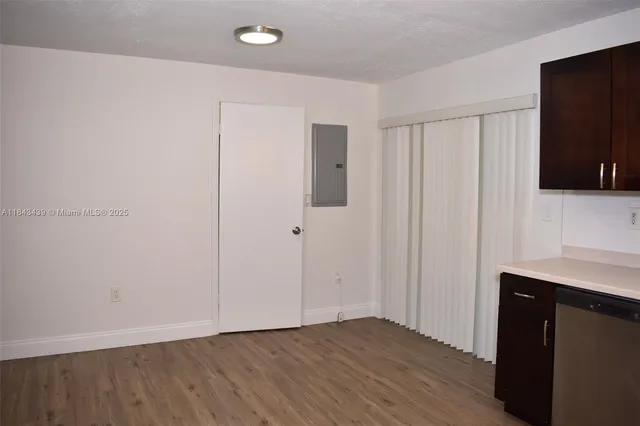 a view of an empty room with wooden floor and closet