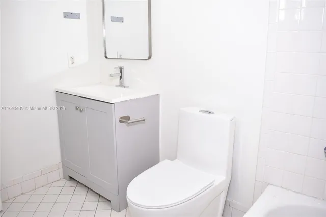 a white toilet sitting next to a bathroom sink