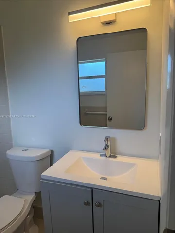 a bathroom with a sink a toilet and mirror