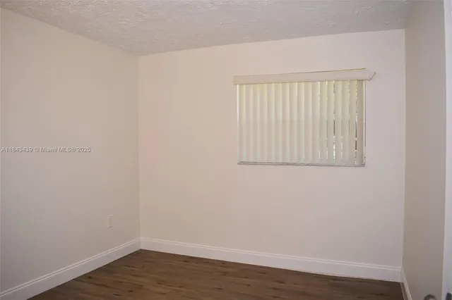 a view of a small space with wooden floor and a window