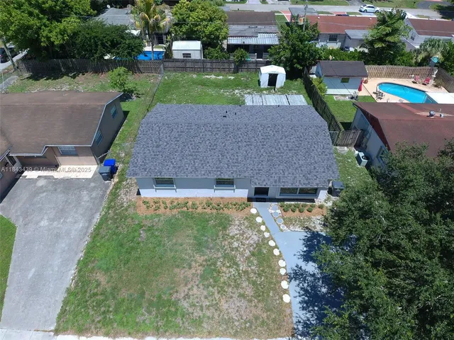 an aerial view of a house with a yard basket ball court and outdoor seating