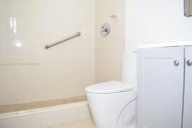 a bathroom with a white toilet and a shower